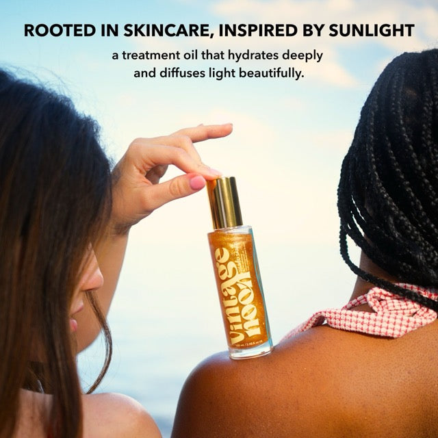 Two women on beach using Gilded Sands treatment oil that hydrates deeply and diffuses light beautifully
