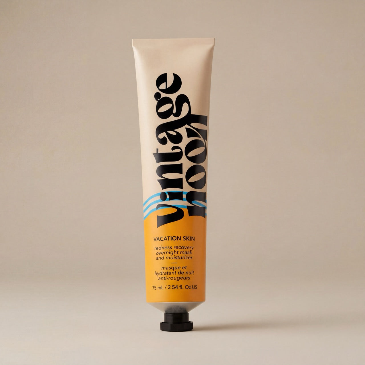 Tube of vintage noon, vacation skin redness recovery overnight mask and moisturizer skincare product on a beige background